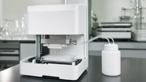 A microplate washer with its stainless manifold lowered over a clear 96-well assay plate on a laboratory bench